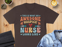 Load image into Gallery viewer, Awesome Hospice Nurse graphic on a brown t-shirt with colorful text and heart monitor.