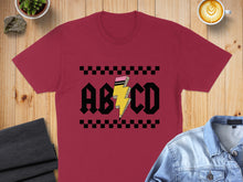 Load image into Gallery viewer, Maroon t-shirt with black and yellow "ABCD" lightning bolt design.