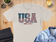 Load image into Gallery viewer, Cream t-shirt with "USA SINCE 1776" text and American flag stripes.