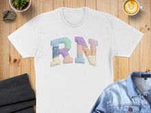Load image into Gallery viewer, White t-shirt with "RN" applique in patchwork fabric, styled with denim jacket and coffee.