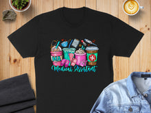 Load image into Gallery viewer, Black t-shirt with "Medical Assistant" text and medical cartoon graphics.