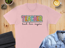 Load image into Gallery viewer, Pink t-shirt with "Teacher" text and "teach love inspire" below.
