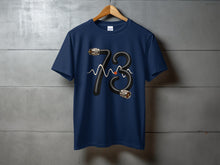 Load image into Gallery viewer, Navy t-shirt with a black cord forming the number 73 and a red dot.