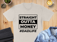 Load image into Gallery viewer, Light tan t-shirt with black text "STRAIGHT OUTTA MONEY #DADLIFE".