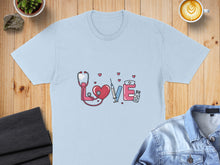 Load image into Gallery viewer, Light blue t-shirt with stethoscope, syringe, and heart graphic.