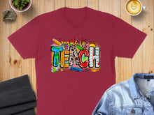 Load image into Gallery viewer, Maroon t-shirt with "Made to Teach" in colorful, playful font with school supplies.
