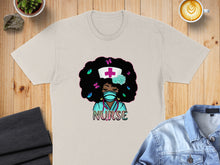 Load image into Gallery viewer, Nurse graphic on a tan t-shirt with butterflies and a stethoscope.