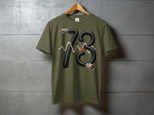 Load image into Gallery viewer, Green t-shirt with "73" graphic made of cable and waveform.