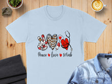 Load image into Gallery viewer, Light blue t-shirt with "Peace love scrub" text, stethoscope, and heart design.