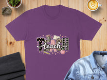 Load image into Gallery viewer, Purple t-shirt with "TEACH" graphic featuring school supplies and patterns.