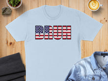 Load image into Gallery viewer, Light blue t-shirt with "BRUH" in American flag graphic text.