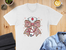 Load image into Gallery viewer, White t-shirt with stethoscope and nurse hat adorned with XOXO ribbon.