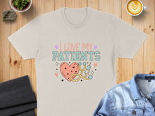 Load image into Gallery viewer, Cream t-shirt with "I love my patients" text and heart, stethoscope, and syringe graphic.