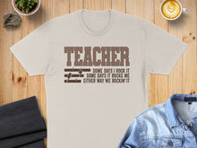 Load image into Gallery viewer, Light beige t-shirt with "TEACHER" and inspirational text.