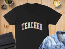 Load image into Gallery viewer, Black t-shirt with "TEACHER" in colorful arched text.