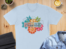 Load image into Gallery viewer, Light blue t-shirt with "Hospice" text surrounded by colorful floral accents.