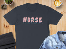 Load image into Gallery viewer, Dark gray t-shirt with "NURSE" in pink and blue text.