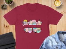 Load image into Gallery viewer, Maroon t-shirt with a split design of colorful pencils with bows and flowers.