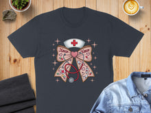 Load image into Gallery viewer, Dark grey t-shirt with a stethoscope, bow, and nurse cap graphic.