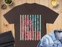 Load image into Gallery viewer, Brown t-shirt with "IT'S A GOOD DAY TO TEACH" text and striped background.