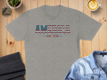Load image into Gallery viewer, Grey t-shirt with "AMERICA EST. 1776" text in red, white, and blue.