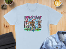 Load image into Gallery viewer, Light blue t-shirt with "lovin' that nurse life" and medical icons.