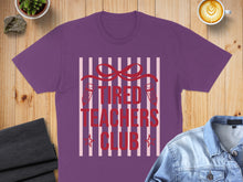 Load image into Gallery viewer, Purple t-shirt with "Tired Teachers Club" text and red ribbon graphic.