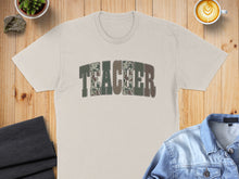Load image into Gallery viewer, T-shirt with "TEACHER" text in camouflage pattern.