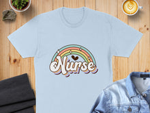 Load image into Gallery viewer, Light blue t-shirt with "Nurse" in pastel rainbow text.