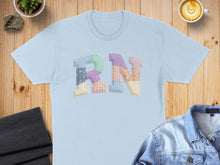 Load image into Gallery viewer, Light blue t-shirt with "RN" in colorful patchwork letters.