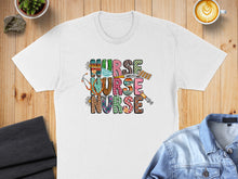 Load image into Gallery viewer, T-shirt with colorful "NURSE" text and medical icons.