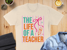 Load image into Gallery viewer, Cream t-shirt with "The Life of a Teacher" text and pencil illustration.