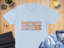 Load image into Gallery viewer, Light blue t-shirt with "Registered Nurse" text in retro floral font.