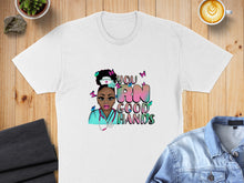 Load image into Gallery viewer, White t-shirt featuring colorful graphic with nurse, butterflies, and text "YOU RN GOOD HANDS".