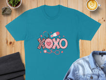 Load image into Gallery viewer, Teal t-shirt with "XOXO" design featuring medical symbols.