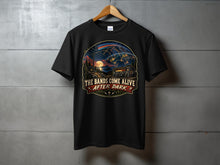 Load image into Gallery viewer, Black t-shirt with a graphic of a radio tower, radio, and earth with arcs. Text reads "THE BANDS COME ALIVE AFTER DARK".