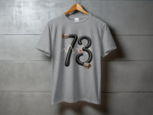 Load image into Gallery viewer, Grey t-shirt with black cord forming the number 73 and a waveform.
