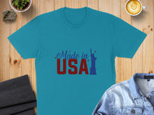 Load image into Gallery viewer, Turquoise t-shirt with "Made in USA" text and Statue of Liberty graphic.