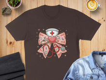 Load image into Gallery viewer, Brown t-shirt with a pink nurse's cap, stethoscope, and "XOXO" pattern.