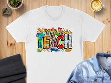 Load image into Gallery viewer, "Made to Teach" graphic on a white t-shirt with school supplies.