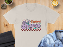 Load image into Gallery viewer, Registered Nurse graphic with stethoscope and syringes on a cream t-shirt.