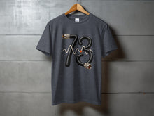 Load image into Gallery viewer, Dark t-shirt with "73" graphic made of coiled cable and waveform.