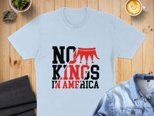 Load image into Gallery viewer, Light blue t-shirt with "NO KINGS IN AMERICA" text and a crown graphic.
