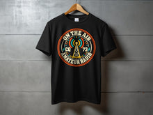 Load image into Gallery viewer, Black t-shirt with "On The Air CQ 73 Amateur Radio" graphic featuring an antenna.