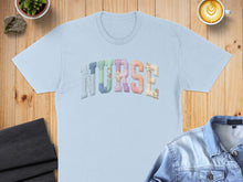 Load image into Gallery viewer, Light blue t-shirt with "NURSE" spelled out in colorful patchwork letters.