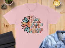 Load image into Gallery viewer, Pink t-shirt with colorful text reading "It takes a lot of sparkle to be a hospice nurse."