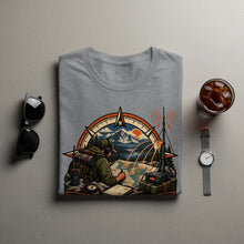 Load image into Gallery viewer, Grey t-shirt with graphic of person planning on map with compass and radio gear