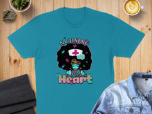 Load image into Gallery viewer, Teal t-shirt with graphic of nurse with afro, hearts, and text "Nursing is a work of Heart".