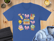 Load image into Gallery viewer, Blue t-shirt with school-themed graphics: bus, globe, books, lightbulb, crayons, and bows.