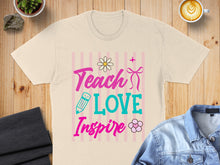 Load image into Gallery viewer, "Teach Love Inspire" text with floral and pencil graphics on a cream t-shirt.